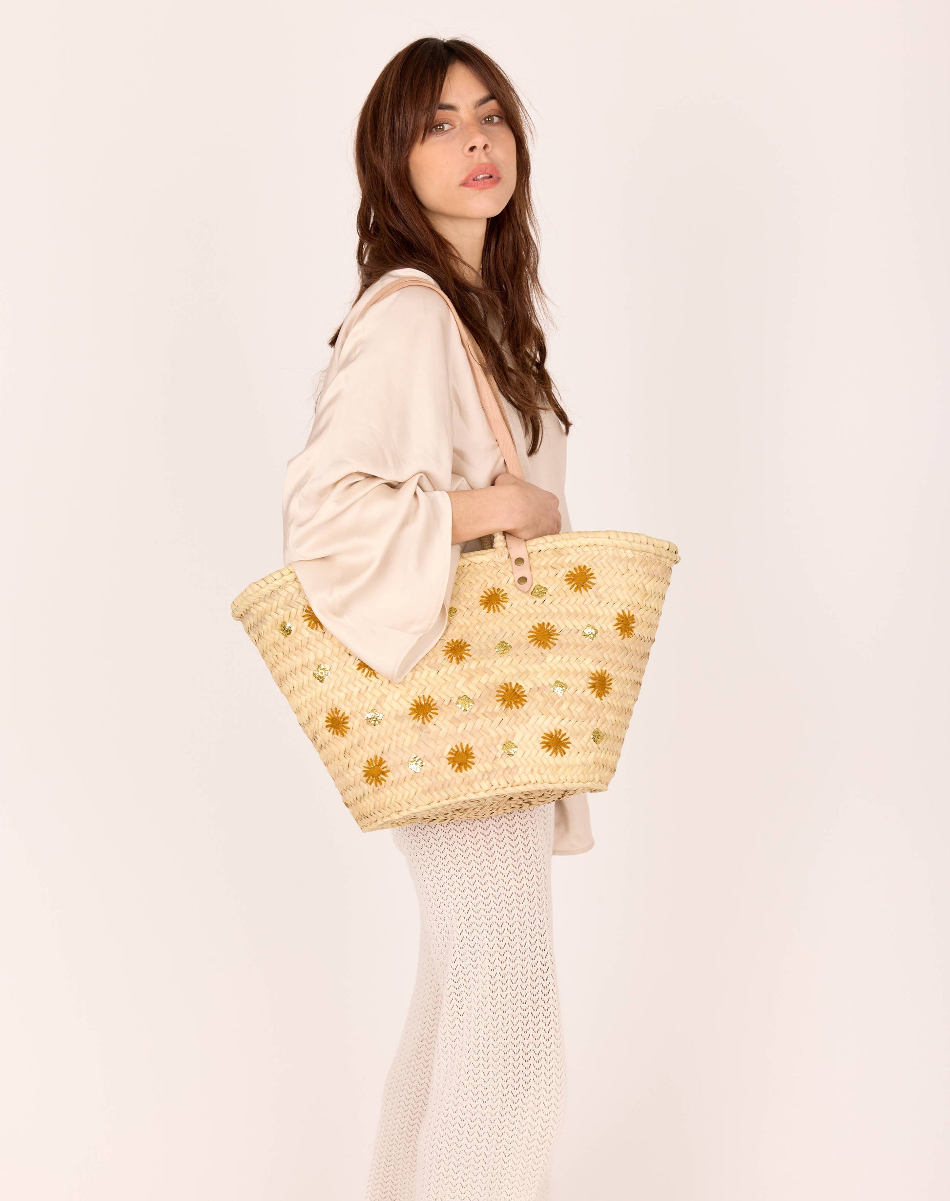 Un panier d’artisanat marocain, aux lignes bohèmes et aux détails précieux : cuir, raphia, broderie lumineuse et patch embossé. Un essentiel de saison.