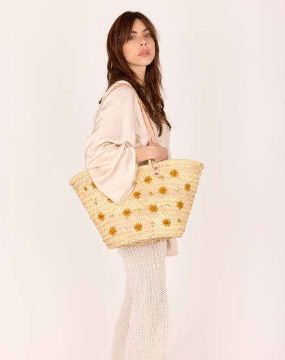 Un panier d’artisanat marocain, aux lignes bohèmes et aux détails précieux : cuir, raphia, broderie lumineuse et patch embossé. Un essentiel de saison.