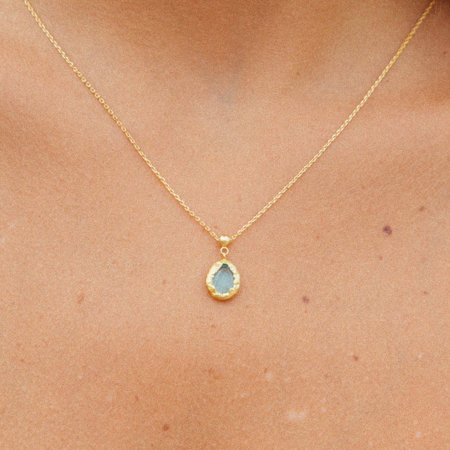 “Breloque Lysia en plaqué or avec pierre en verre turquoise, inspirée par la mer, fabriquée de manière éthique en France, Agapée.”