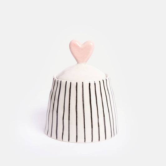 “Petit bocal rayé en grès avec un couvercle en forme de cœur, décoré d’une glaçure peinte à la main, parfait pour le rangement ou la décoration, signé Caroline Gardner.”