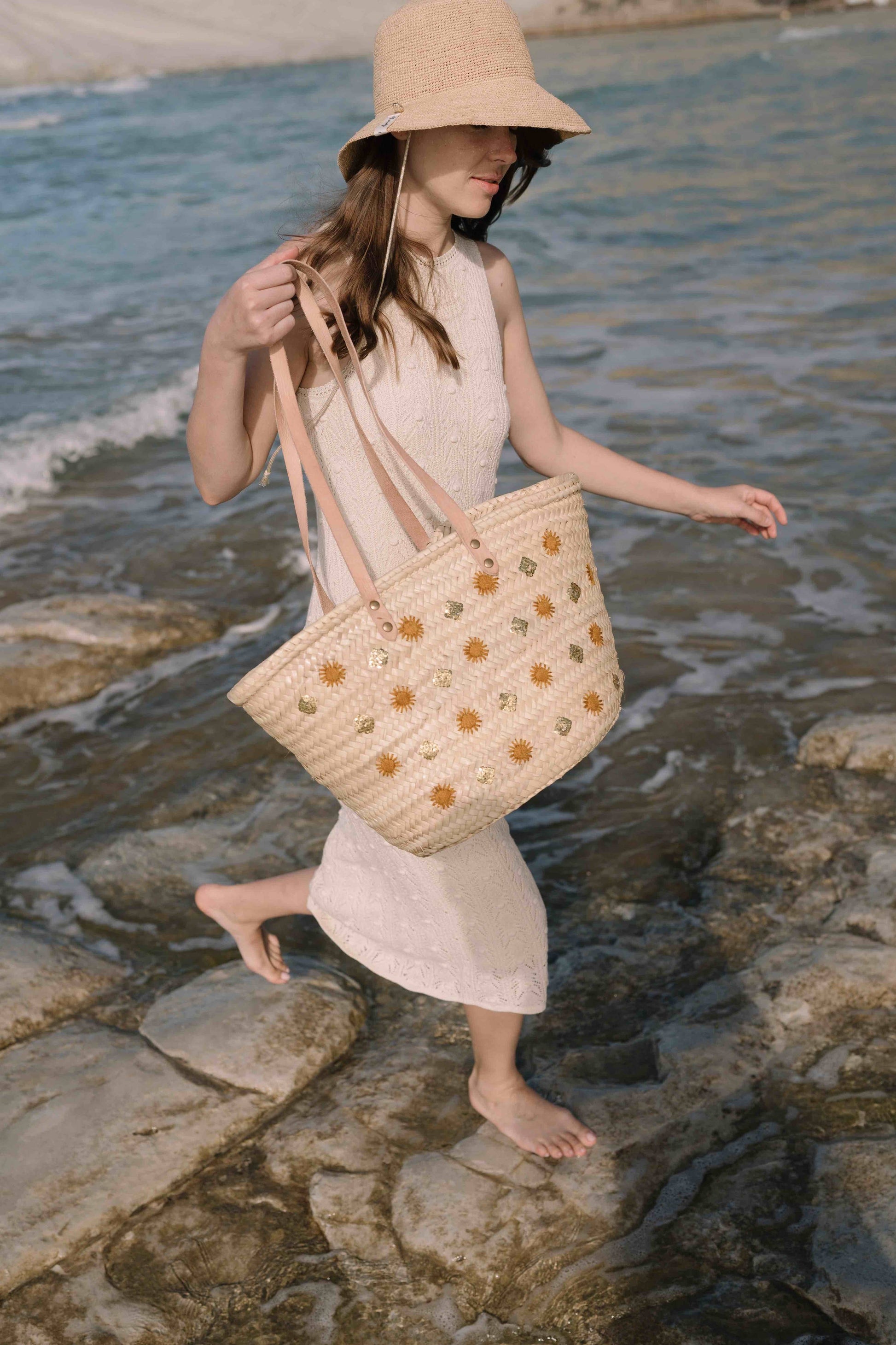 Un panier d’artisanat marocain, aux lignes bohèmes et aux détails précieux : cuir, raphia, broderie lumineuse et patch embossé. Un essentiel de saison.