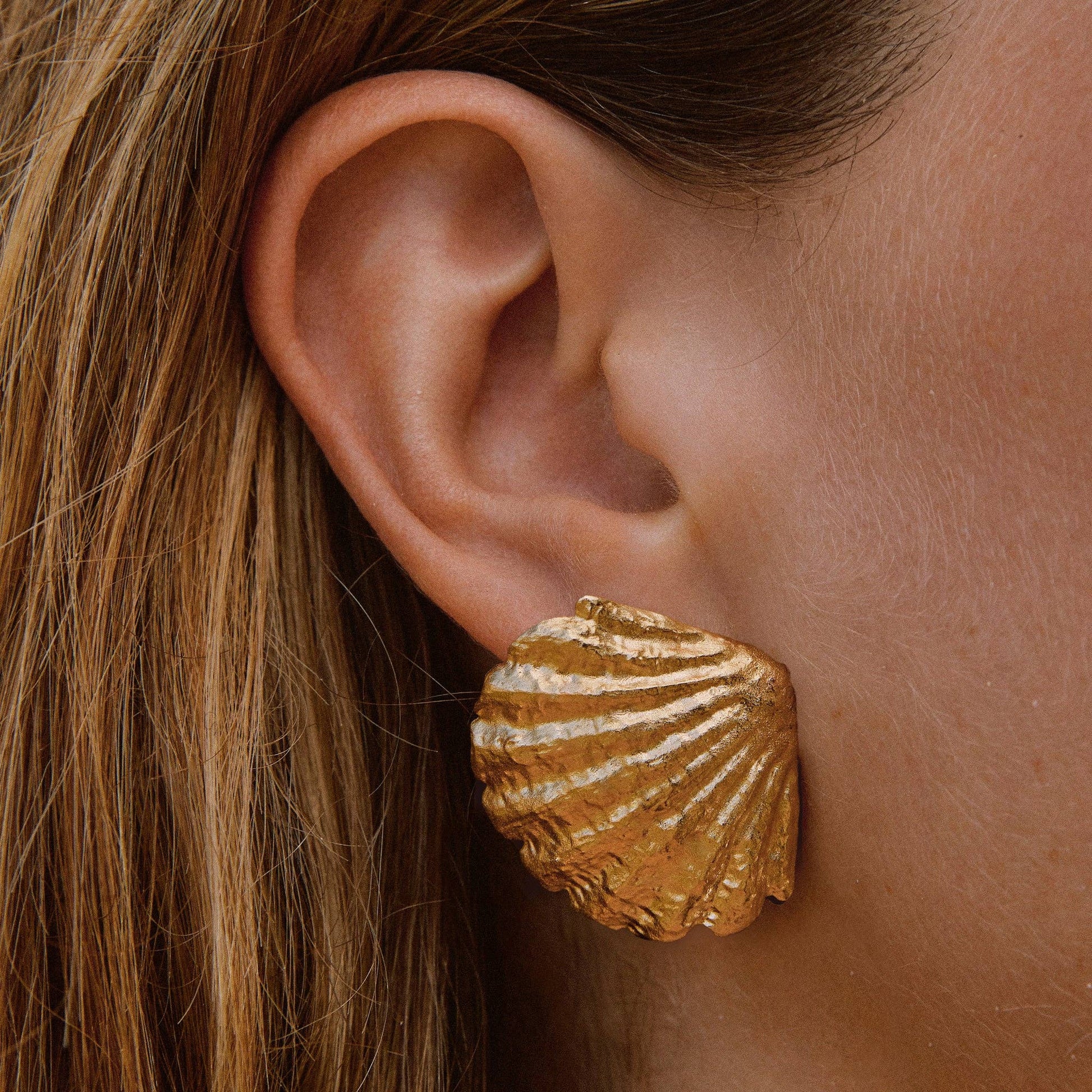 Boucles d’oreilles coquillage dorées à l’or fin, bijou sculptural inspiré de la mer, fabriqué en France.
